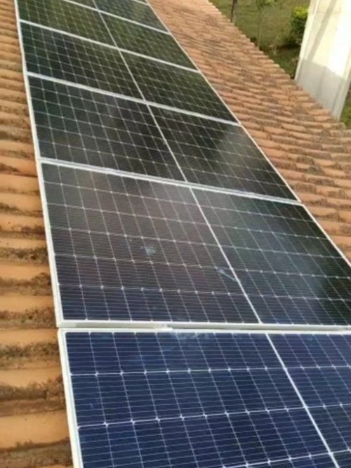 Módulos solares instalados sobre telhado de telha cerâmica.